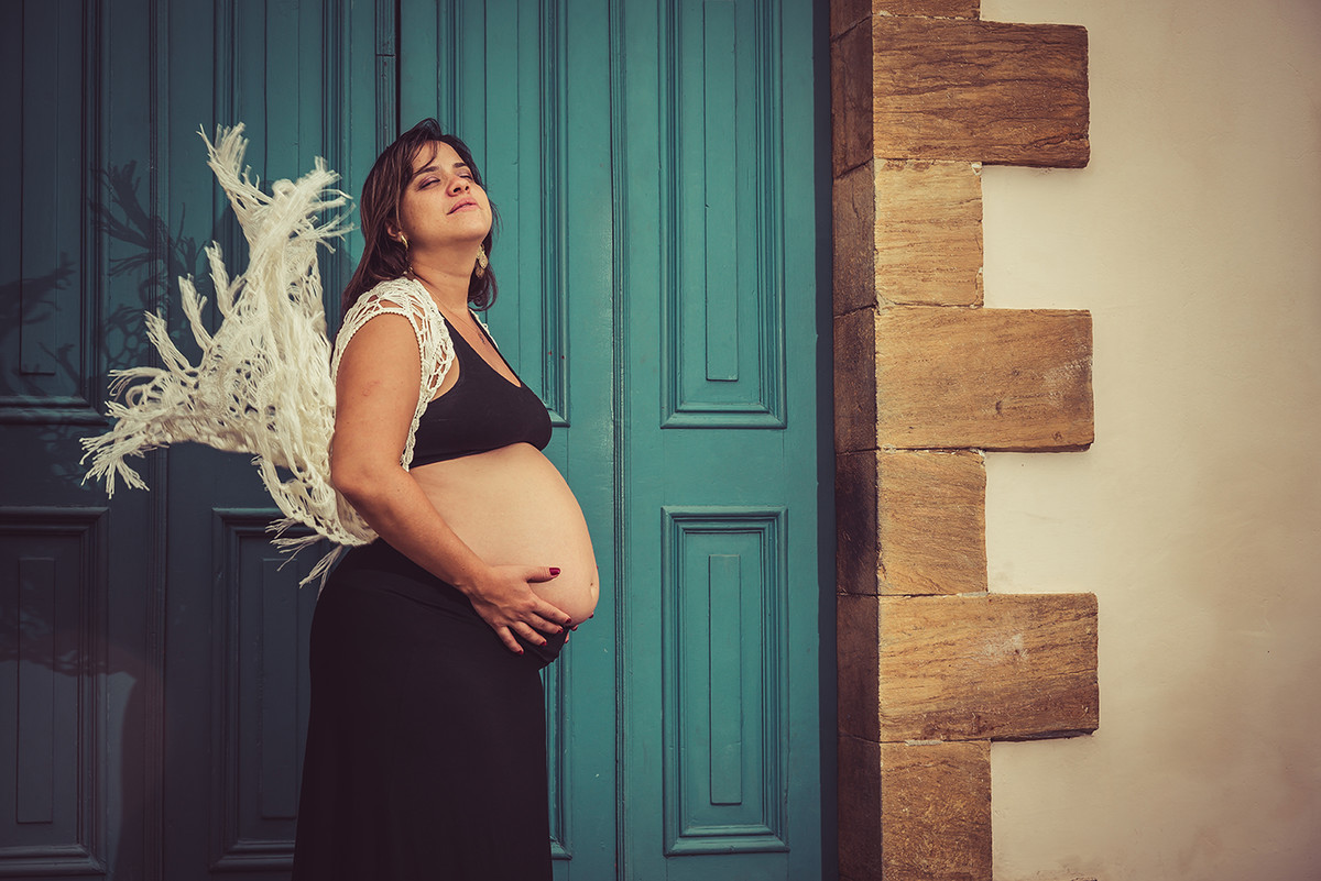 grávida com a roupa voando em frente a uma igreja no ensaio de gestante em Ouro preto MG