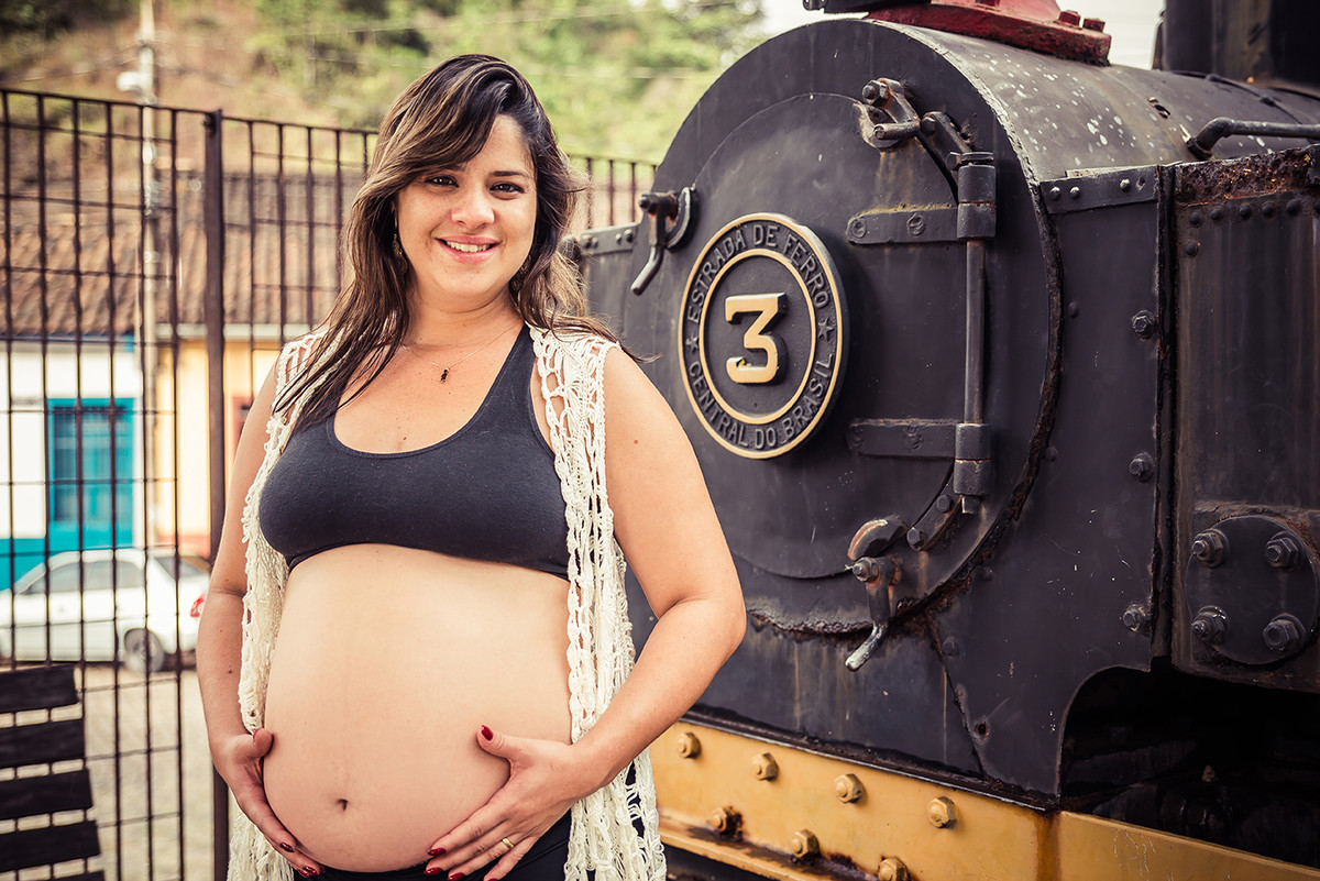gestante em frente a locomotiva na estação de trem em Ouro preto