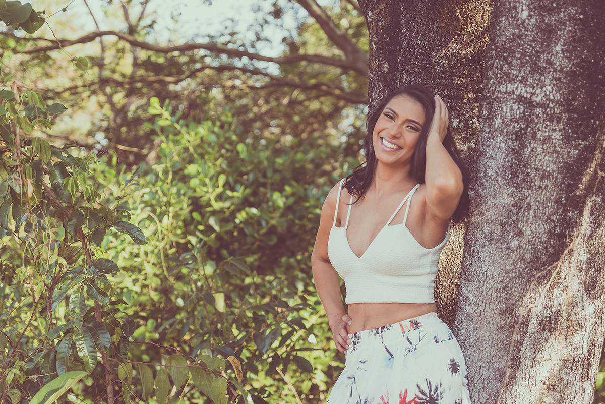 Debutante sorrindo encostada na árvore no book feminino feito em Lagoa Santa MG