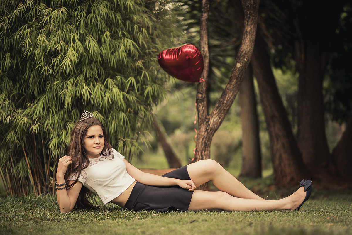 Modelo deitada segurando balão de coração no ensaio de debutante feito pelo fotógrafo de 15 anos em Belo Horizonte BH MG