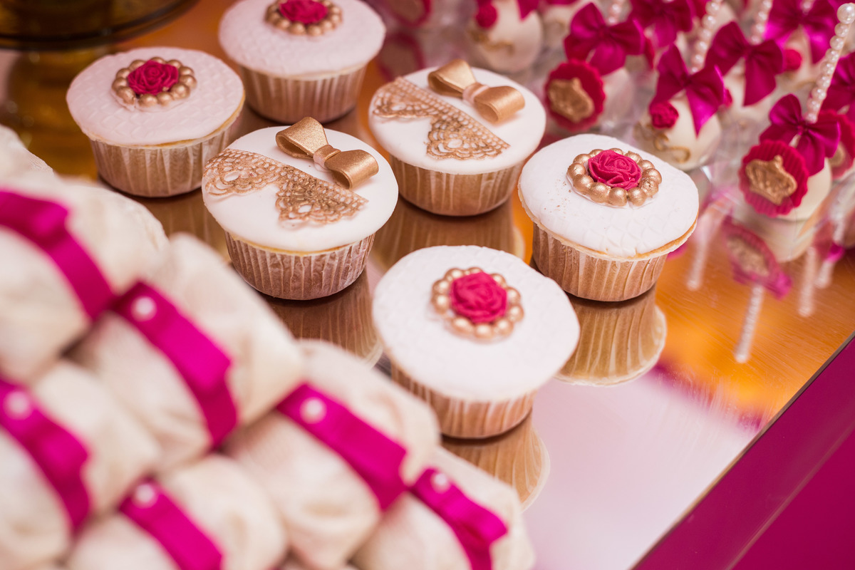 doces enfeitando a mesa principal, coroas e laços dão um charme a esses deliciosos docinhos