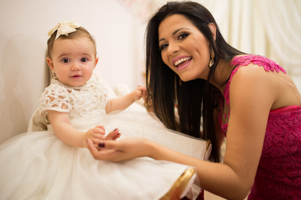 mamãe e bebê rindo e olhando para a foto 