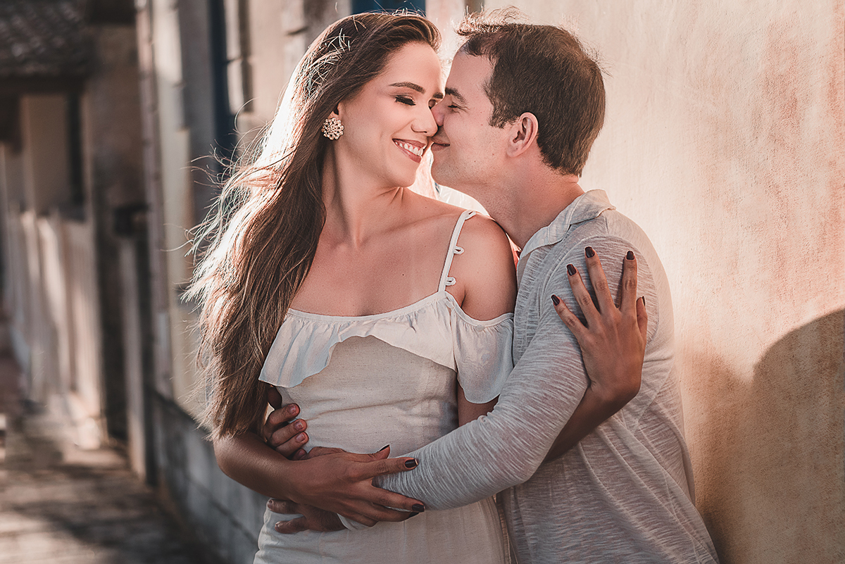 Ensaio_précasamento_Renata_e_Otávio_Ceará-Mirim_Rio_Grande_do_Norte_14_10_2019 Casal abraçado com os rostos encostados enquanto sorriem enquanto a luz do sol ilumina seus cabelos.