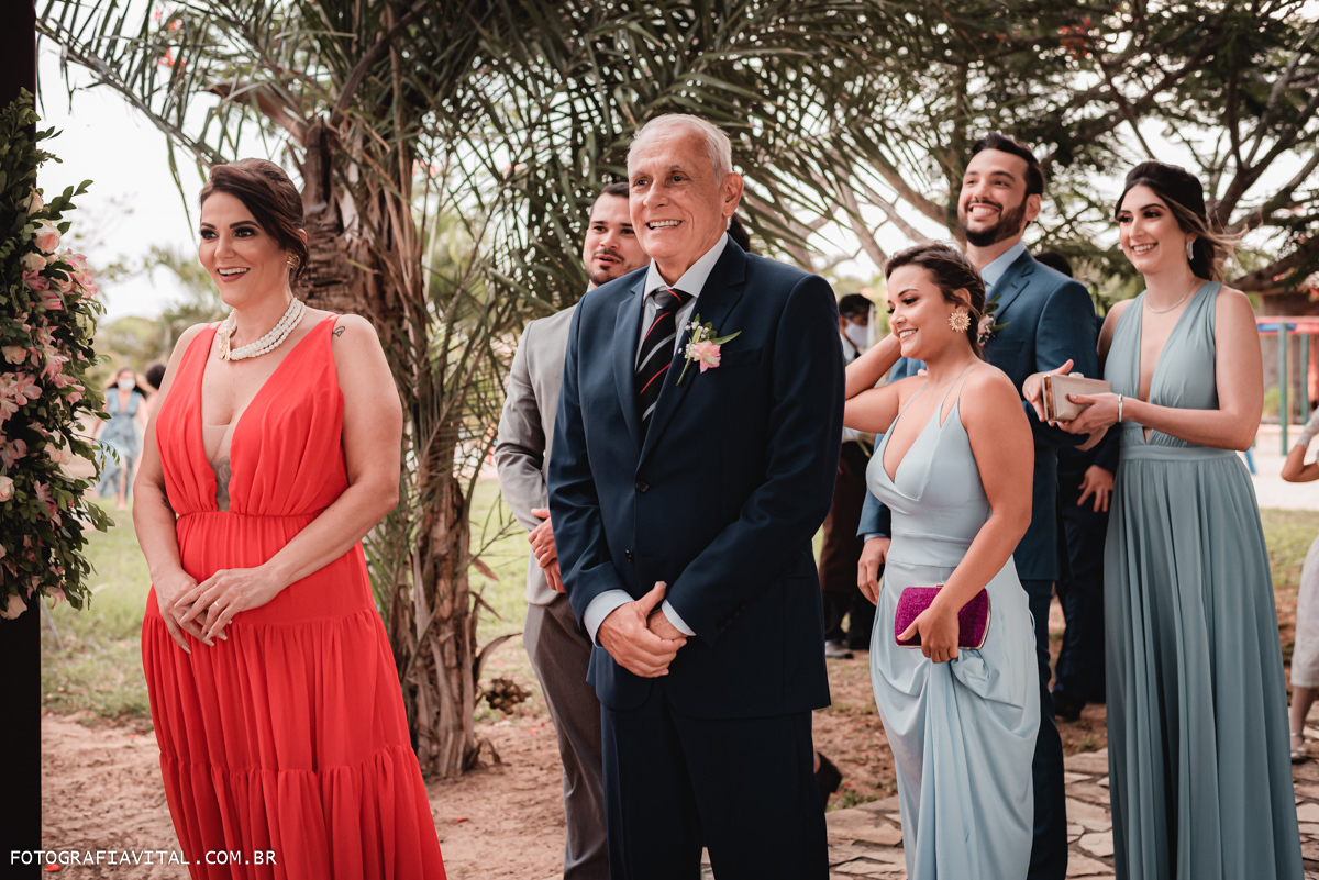 Fazenda Real III - Macaíba - RN - Convidados, pais e padrinhos de pé fora da igreja esperando para entrarem.