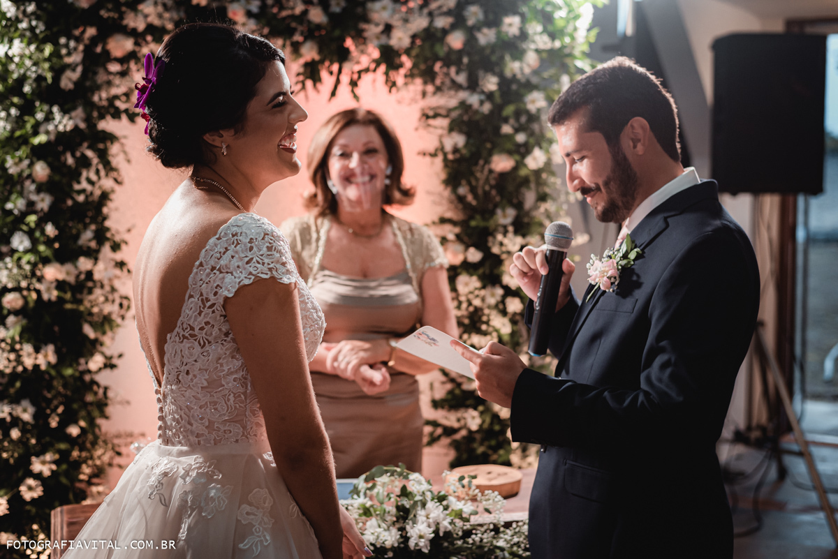 Fazenda Real III - Macaíba - RN - Momento dos votos do casal. Amobos os noivos estão sorrindo, junto com a celebrante.