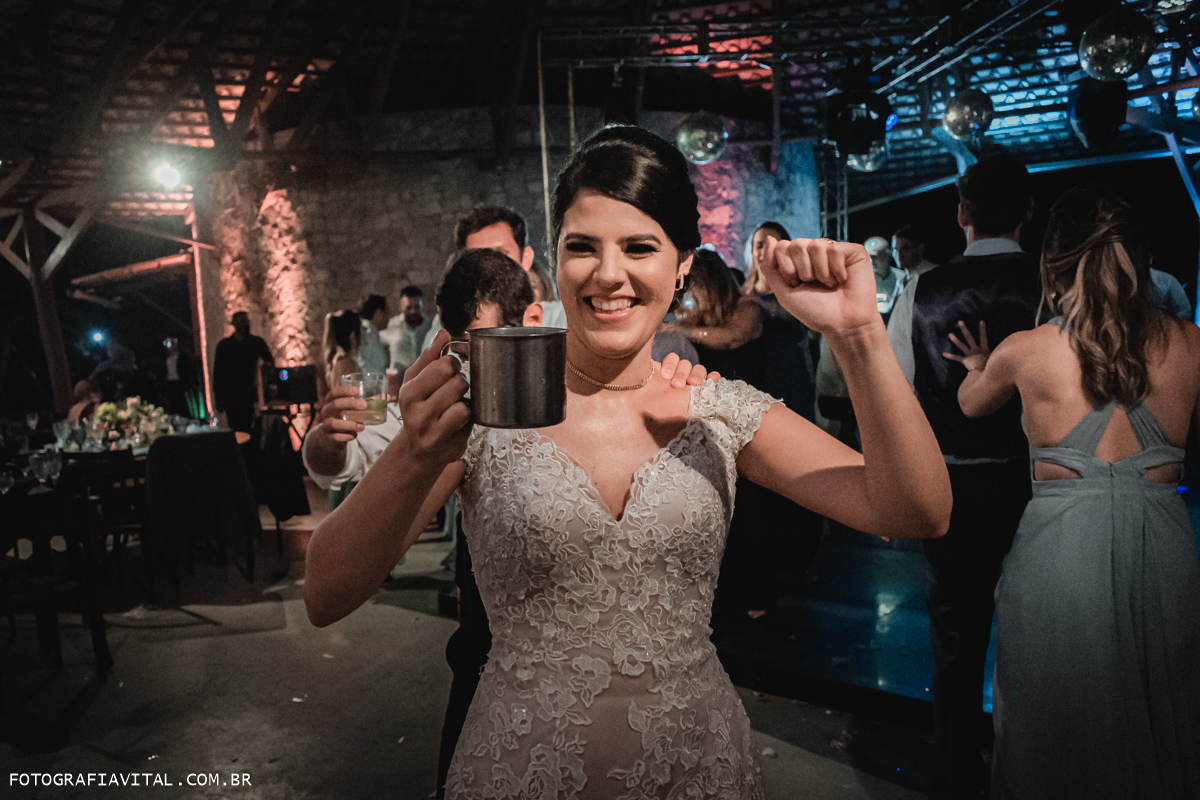 Fazenda Real III - Macaíba - RN - Close da noiva segurando uma caneca de drink e encabeçando um trenzinho com os convidados.