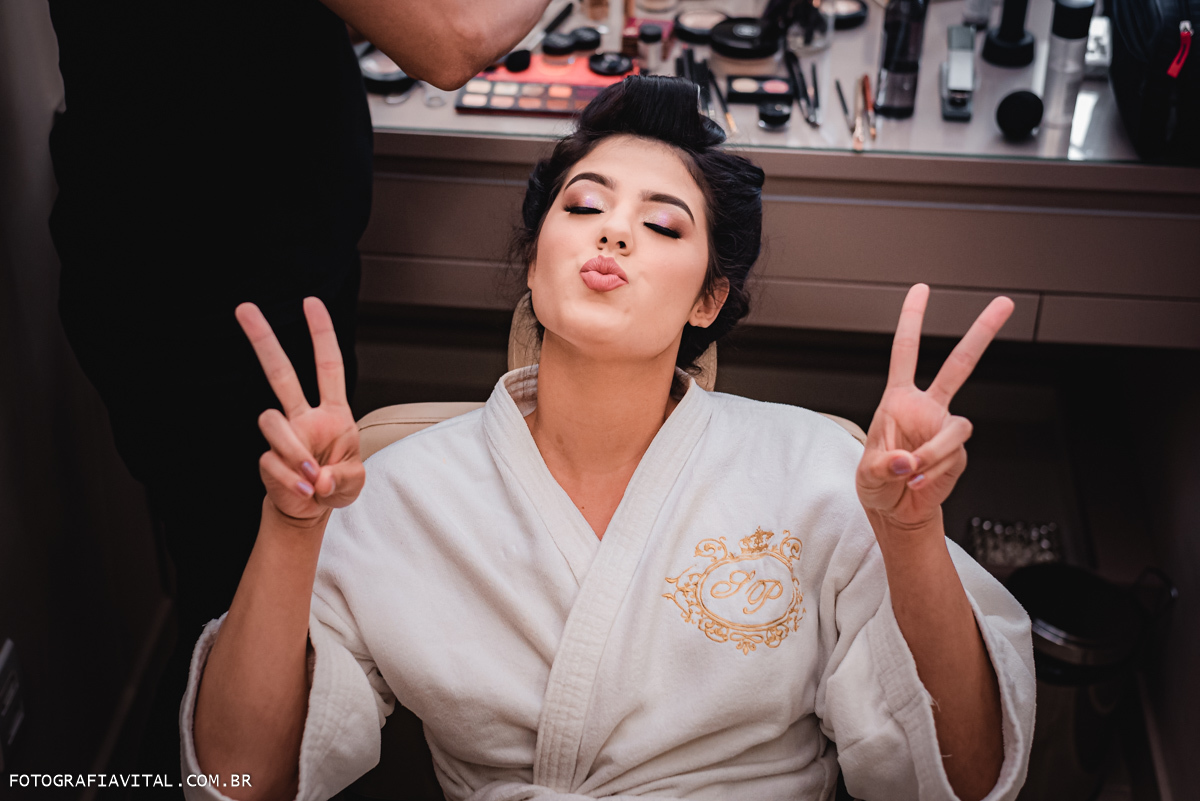 Estúdio Pontes - Natal - RN - a noiva vai biquinho de beijo enquanto suas mãos estão fazendo sinal de paz e amor para a câmera.