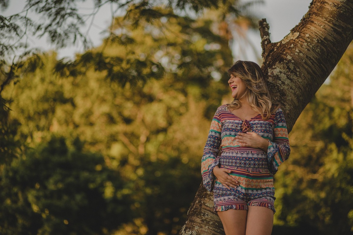 gestante sorrindo e tocando a barriga
