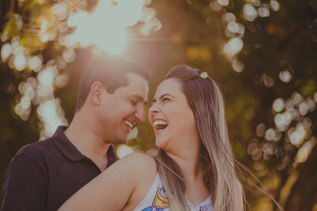 casal sorrindo, luz do sol ao fundo