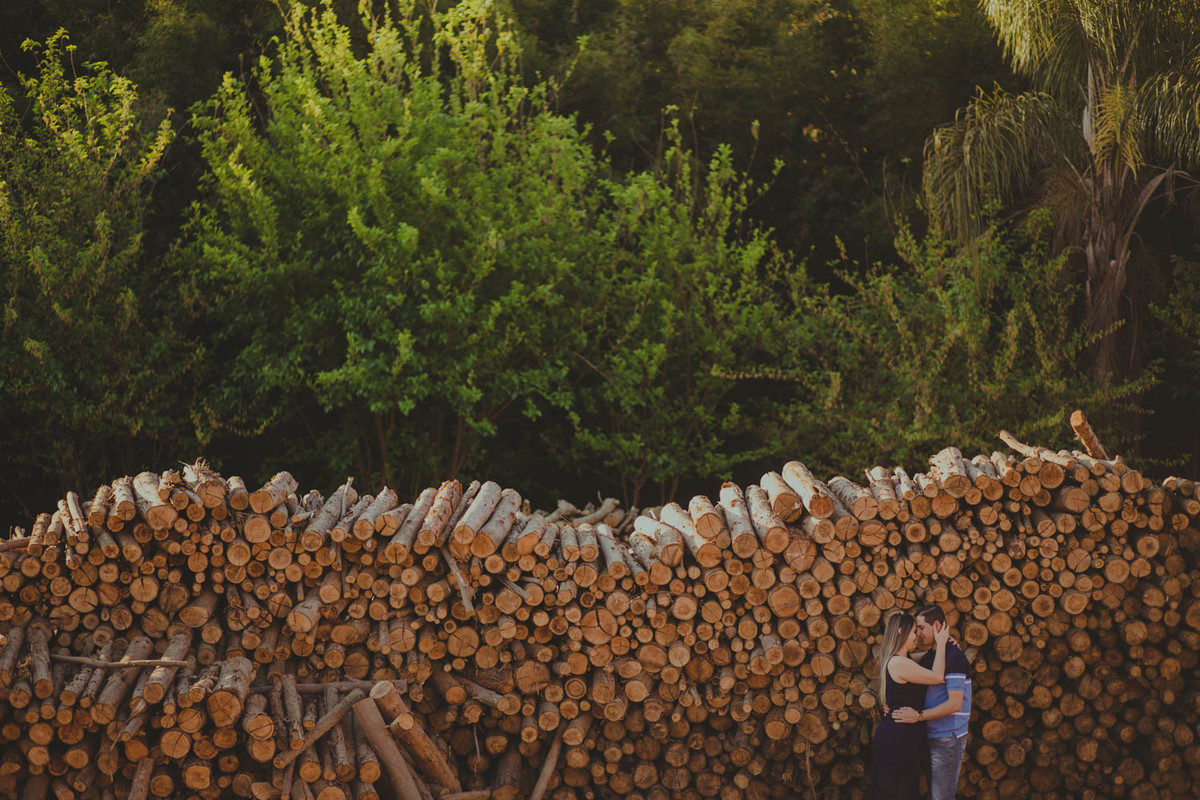 casal abraçado proximo ao monte de madeira