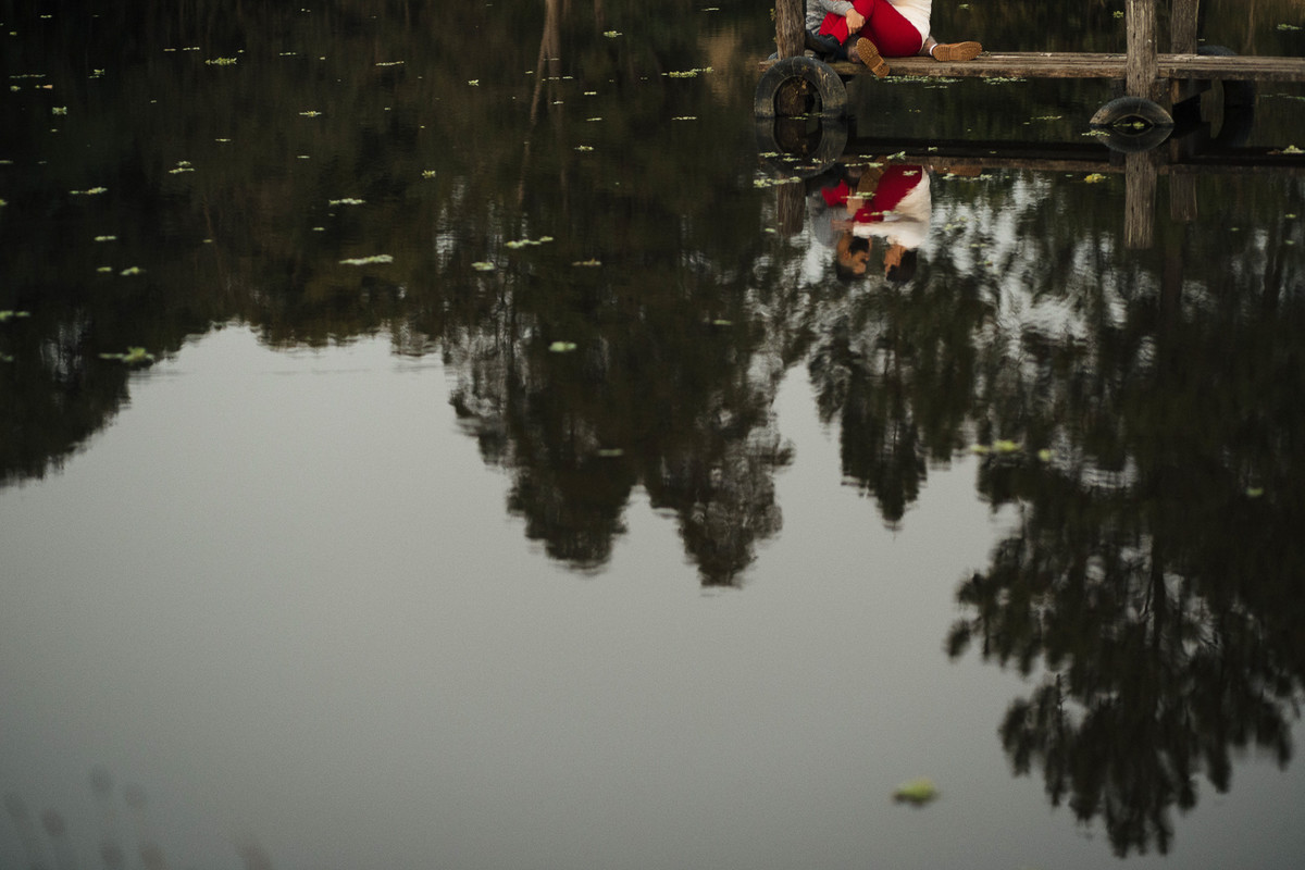 reflexo na agua casal parado no pier curtindo um fim de tarde