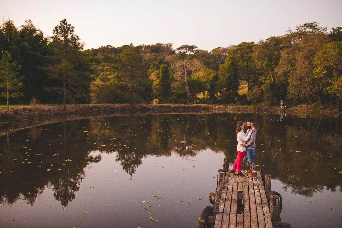 casal namorando no deck na beira do lago,