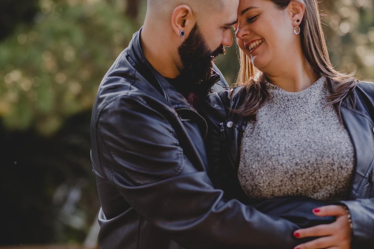 homem barbudo de jaqueta de couro abraçado com sua noiva