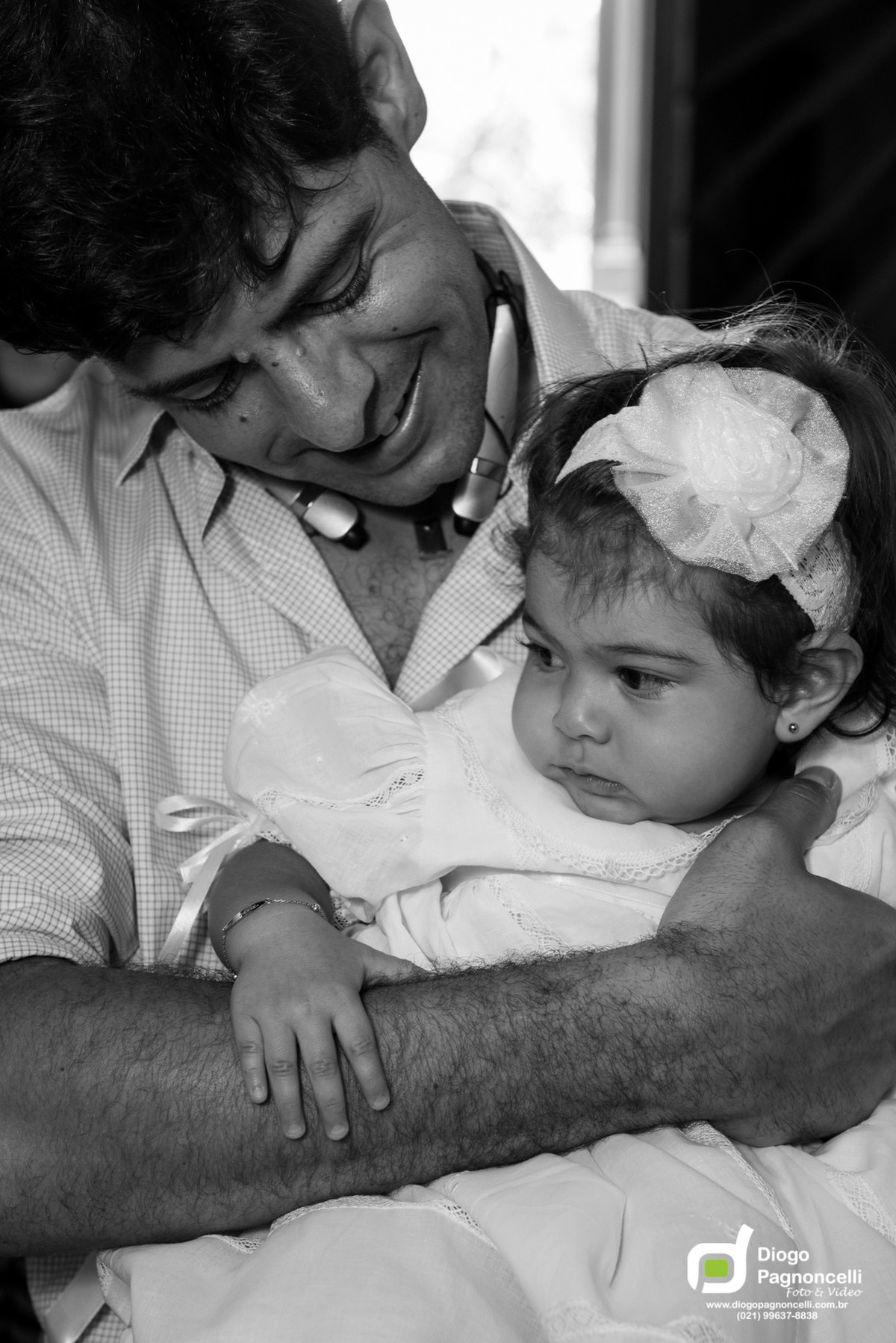 Pai olhando para a filha que será batizada. Foto Diogo Pagnoncelli.