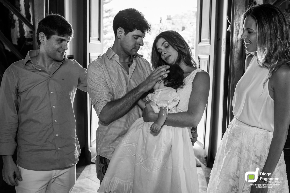 Pais e padrinhos fazendo o sinal da cruz na filha na porta da igreja durante a cerimonia do batizado. Foto Diogo Pagnoncelli.