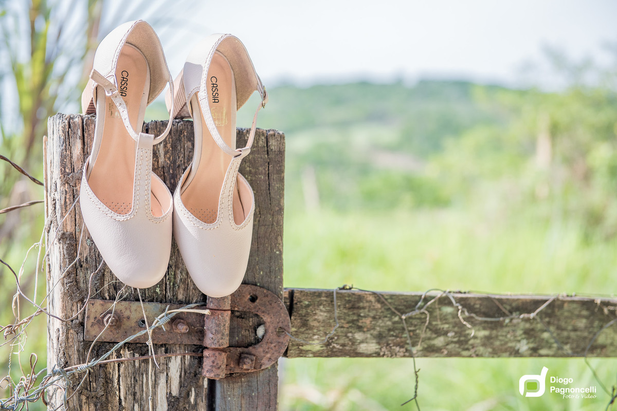 Sapatos da noiva em porteira de fazenda com arame farpado na madeira. Foto Diogo Pagnoncelli.