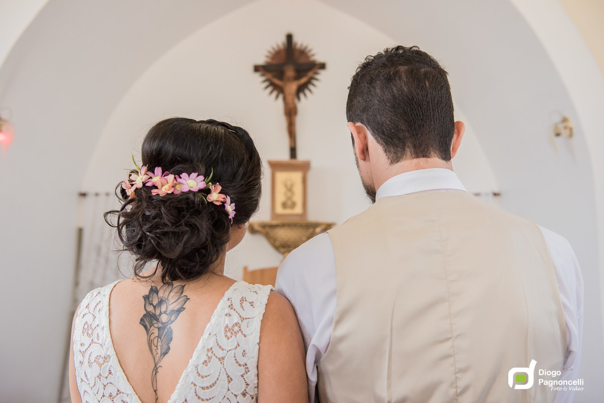 Noivos na igreja com a imagem de Jesus ao fundo. Foto Diogo Pagnoncelli.