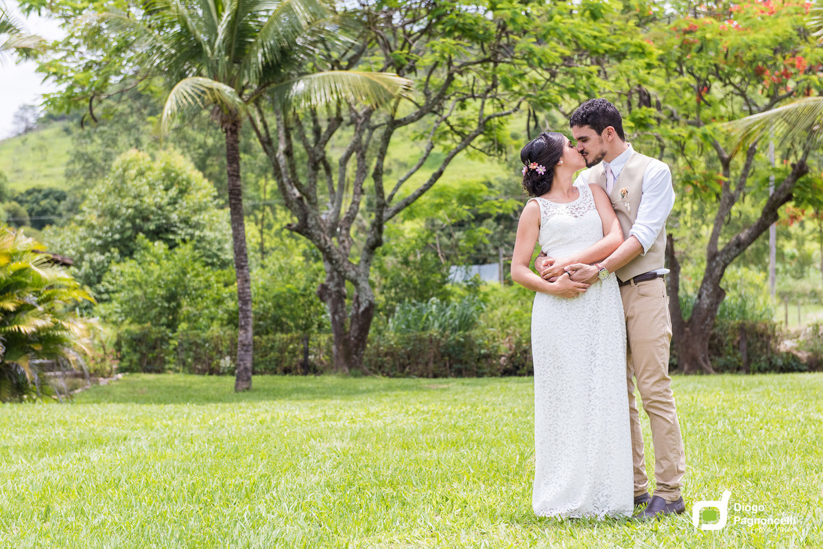 Noivos apaixonado se beijando com a fazenda de fundo. Foto Diogo Pagnoncelli.