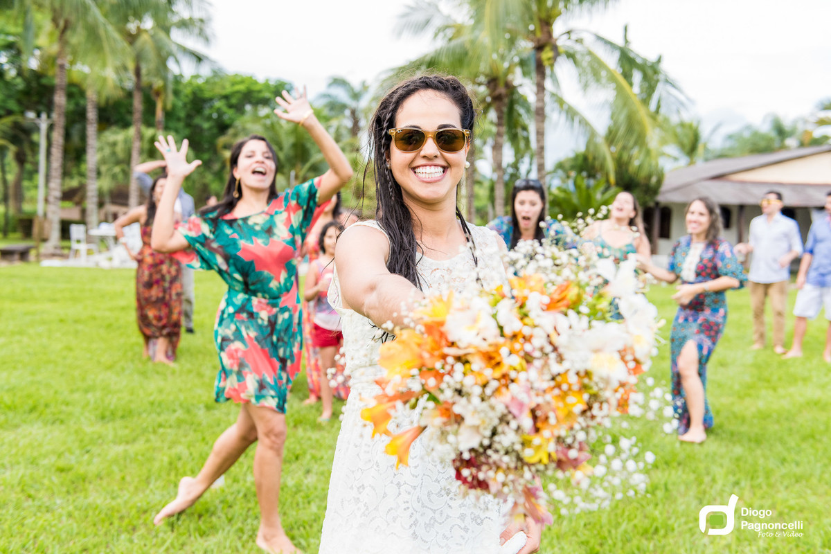 Noiva se preparando para jogar o bouquet enquanto as amigas ficam alvoraçadas ao fundo. Foto Diogo Pagnoncelli.