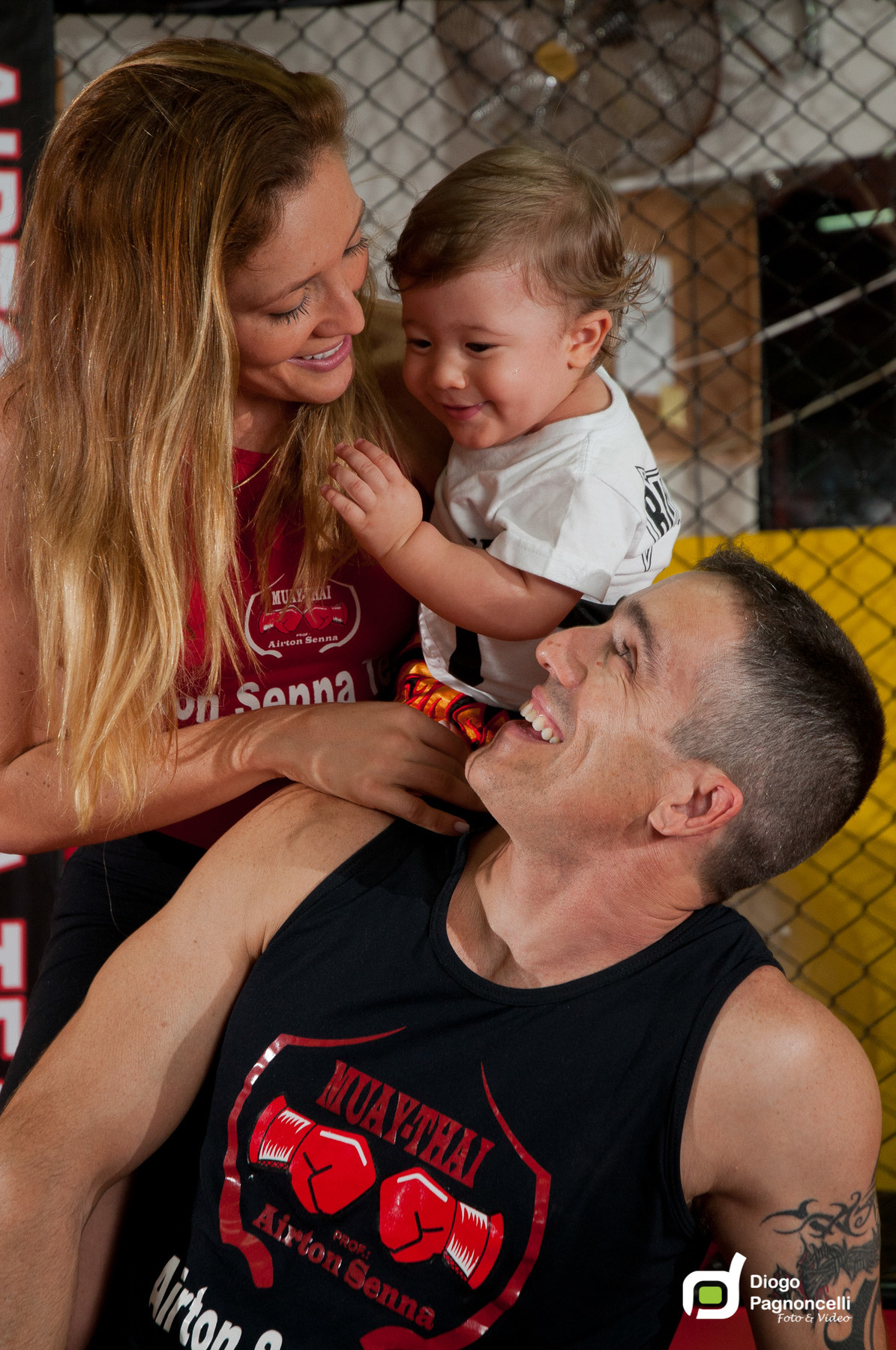 Mãe e pai se olhando e filho sorrindo no colo da mãe na academia de ginastica da família. Foto Diogo Pagnoncelli
