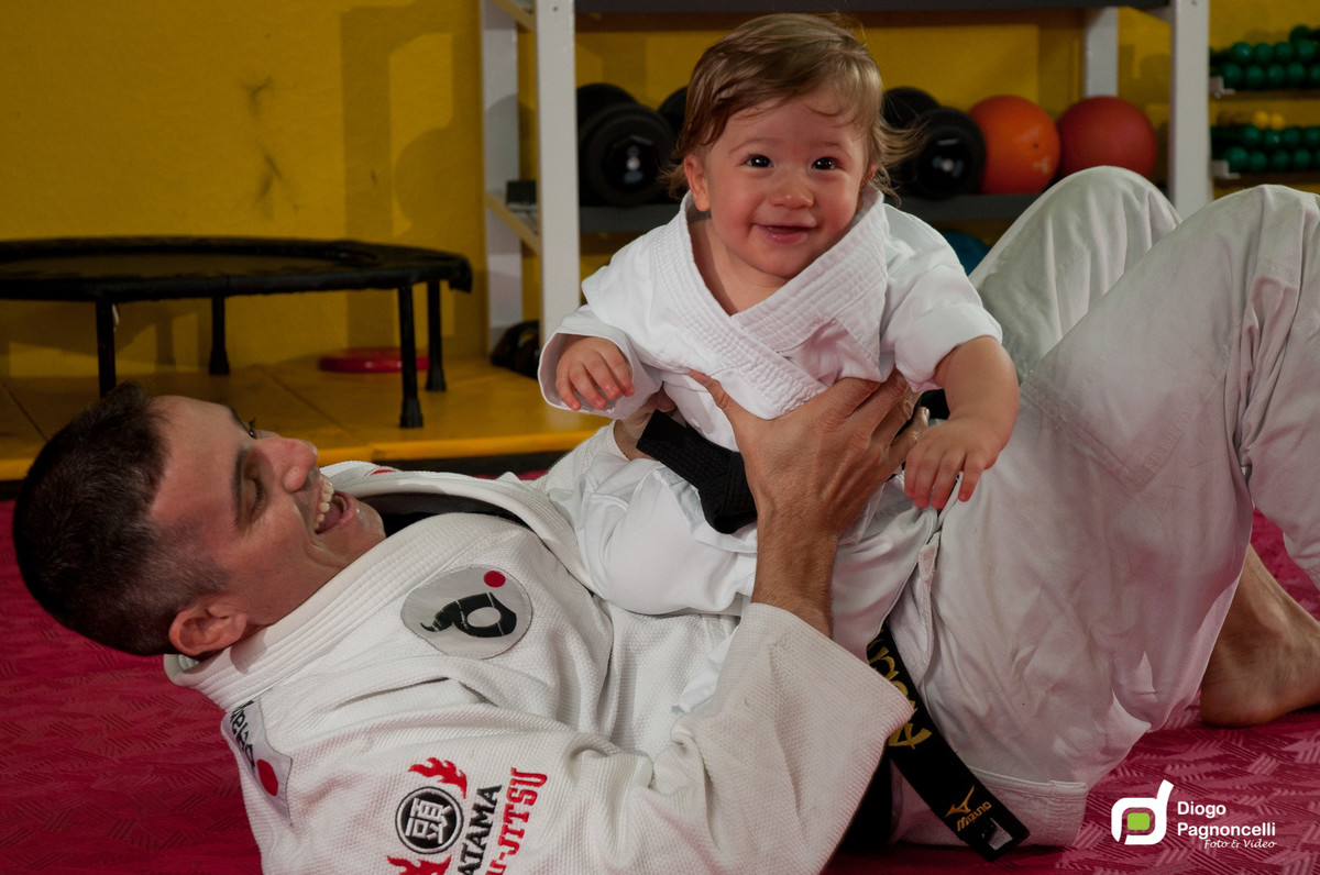 Pai e filho de quimono brincando de Jiu-jitsu na academia de ginastica da família. Foto Diogo Pagnoncelli