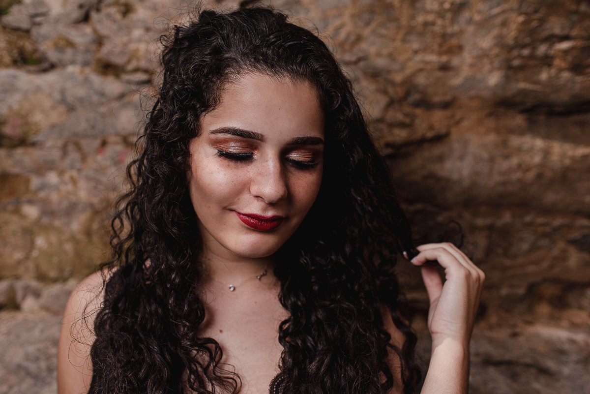 passando a mão no cabelo e olhando para baixo