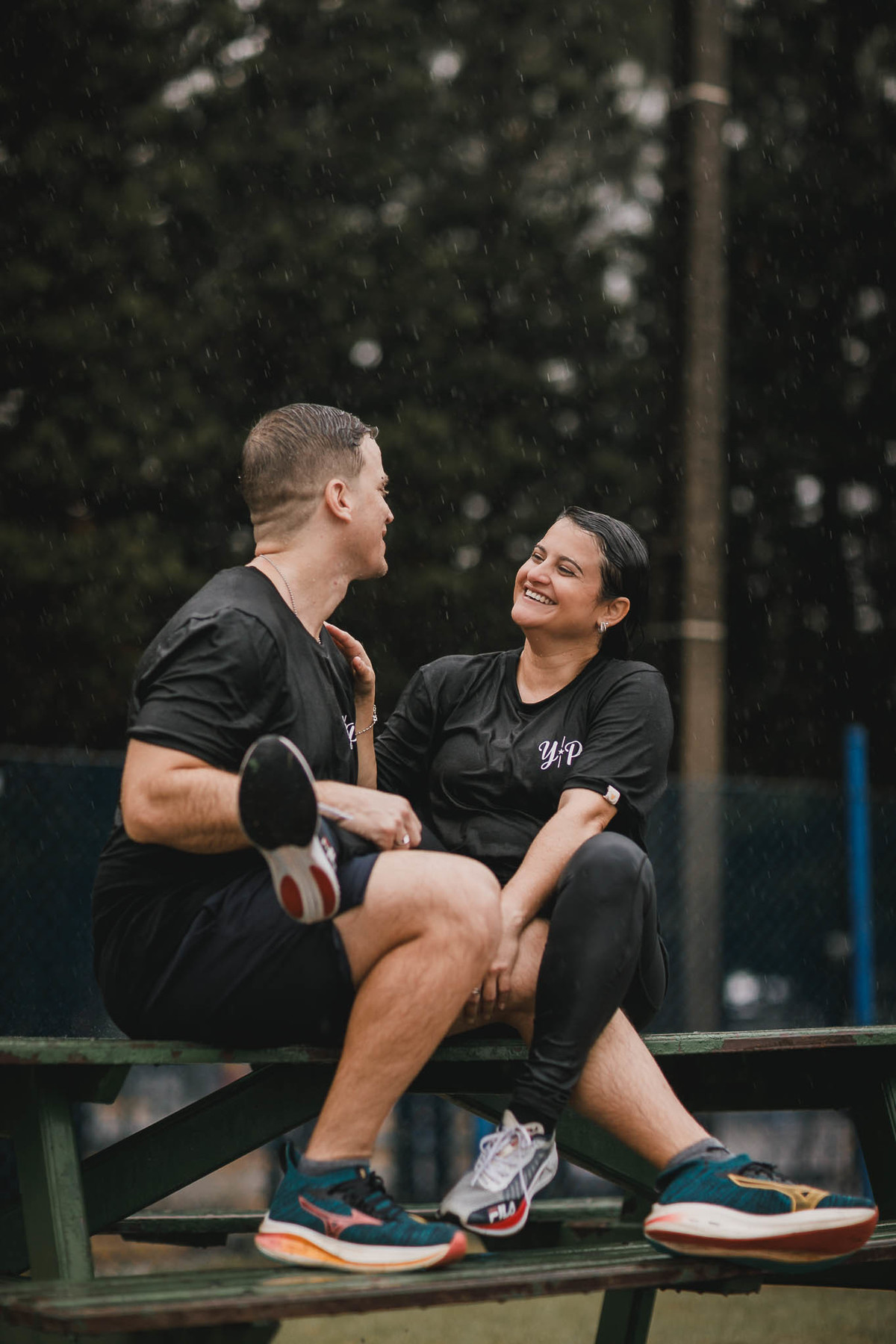 Fotos de pre-wedding na chuva na pista de atletismo.