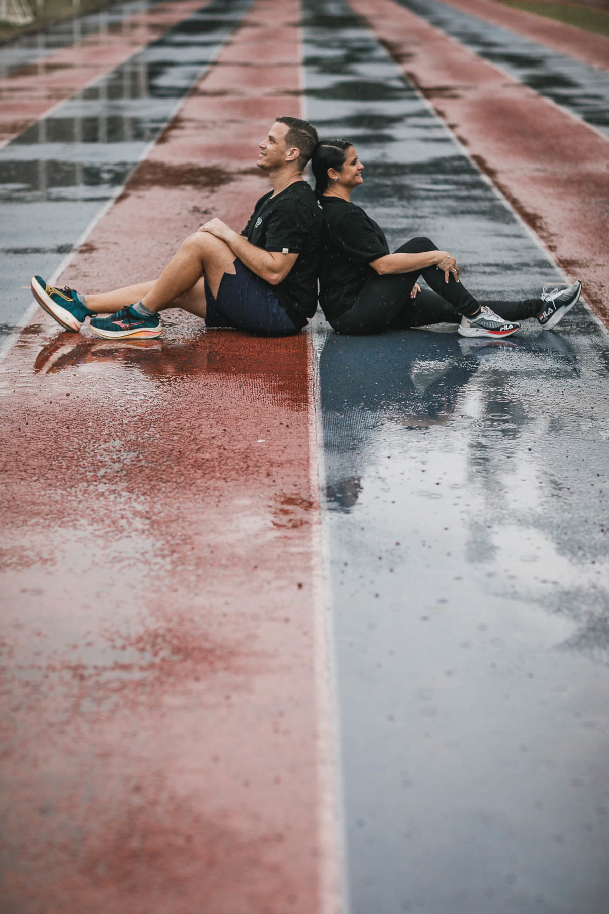Fotos de pre-wedding na chuva na pista de atletismo.