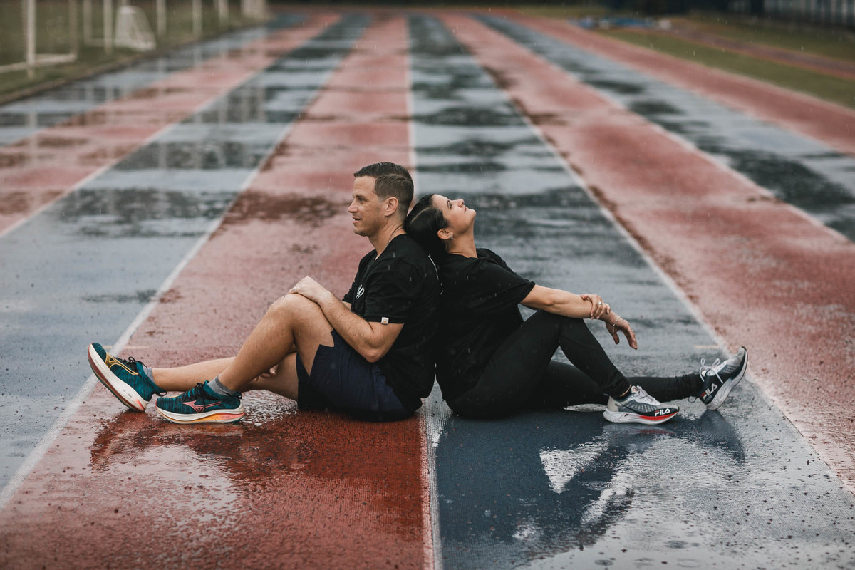 Fotos de pre-wedding na chuva na pista de atletismo.