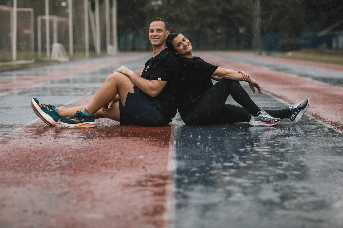 Fotos de pre-wedding na chuva na pista de atletismo.