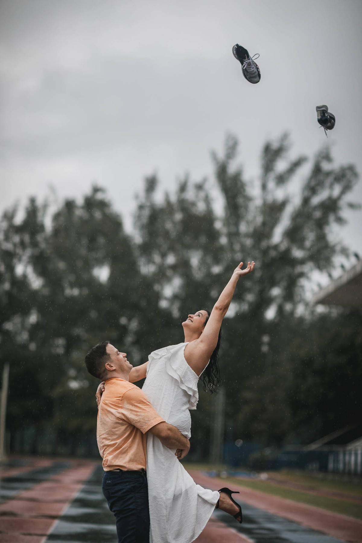 Fotos de pre-wedding na chuva na pista de atletismo.