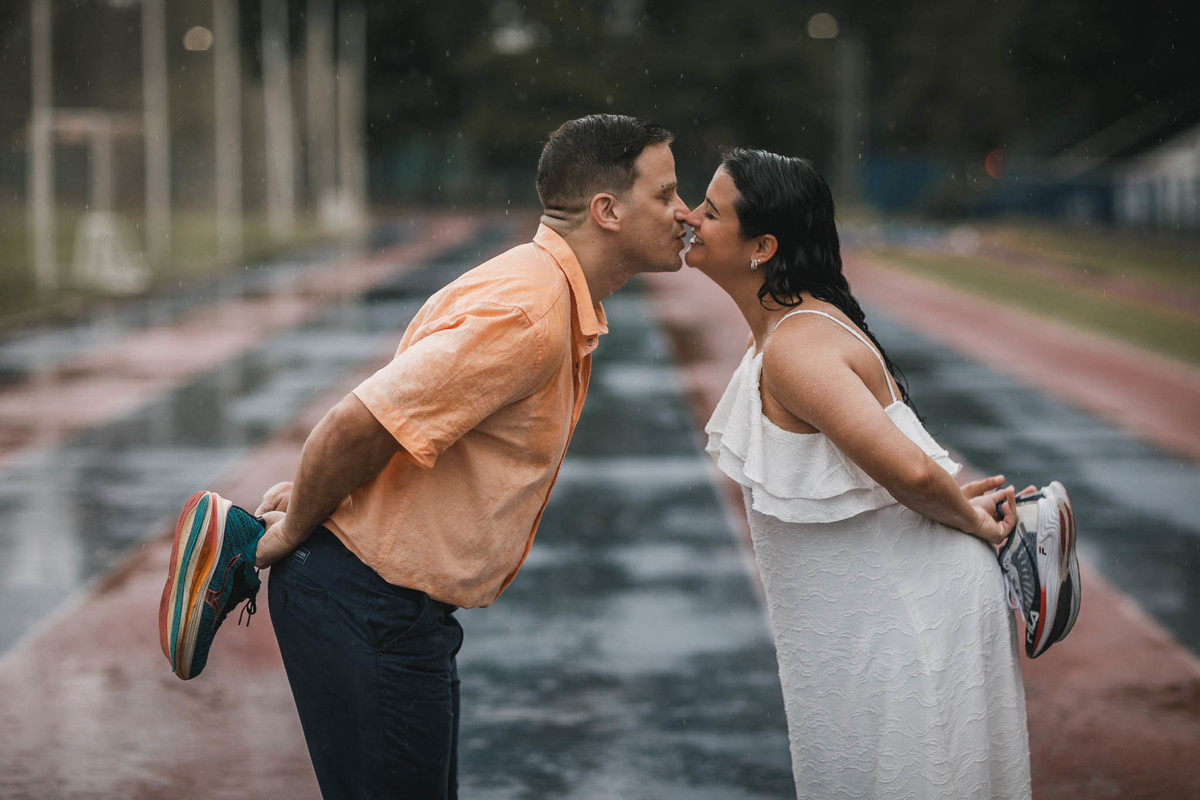 Fotos de pre-wedding na chuva na pista de atletismo.