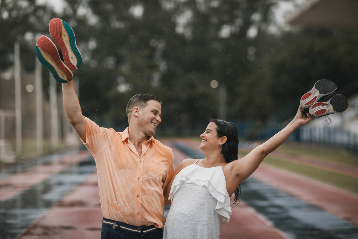 Fotos de pre-wedding na chuva na pista de atletismo.