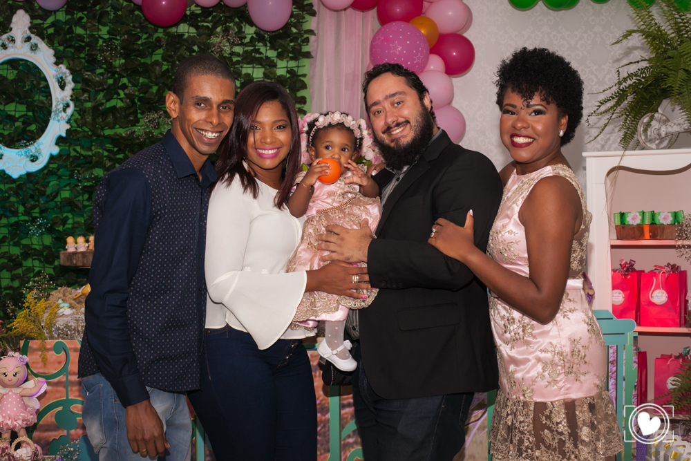 O padrinhos enchendo a criança de amor e carinho, pousando para foto.