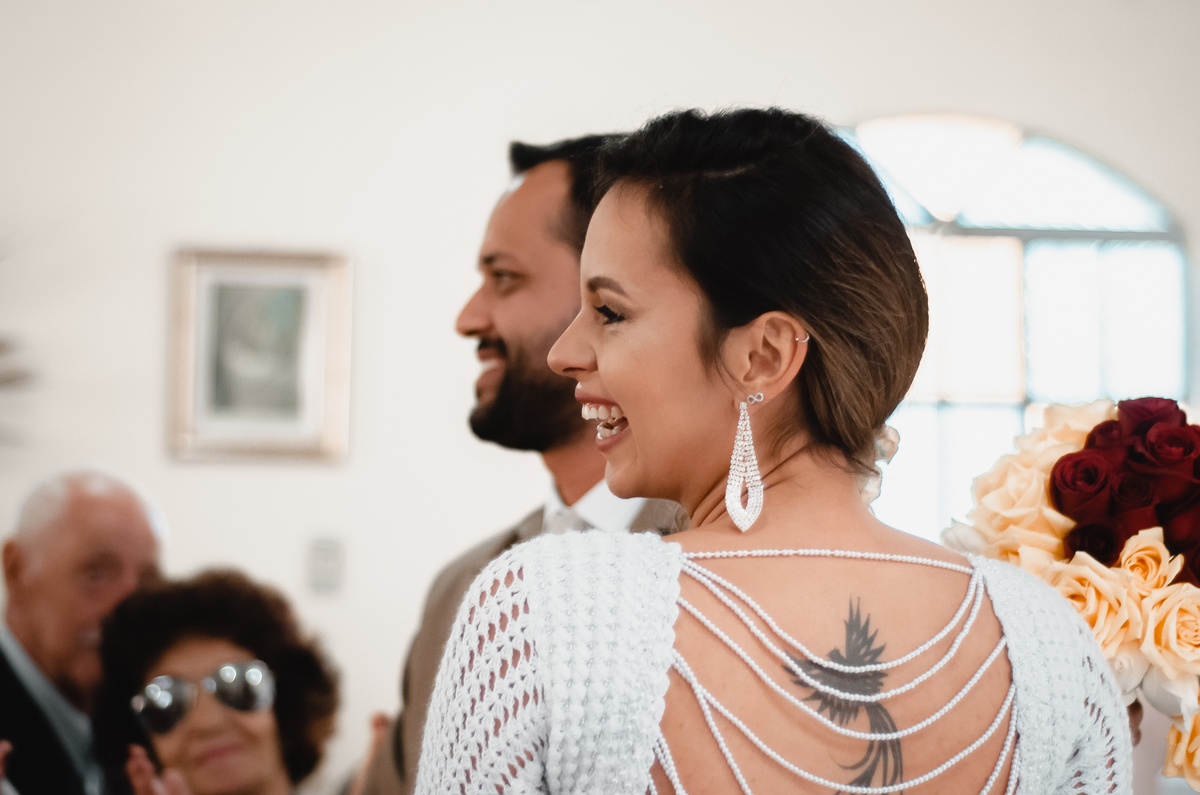Fotografo de Casamento em Valença - RJ. Casamento em Rio Preto Minas Gerais. Foto da noiva e do noivo olhando para os convidados e sorrindo