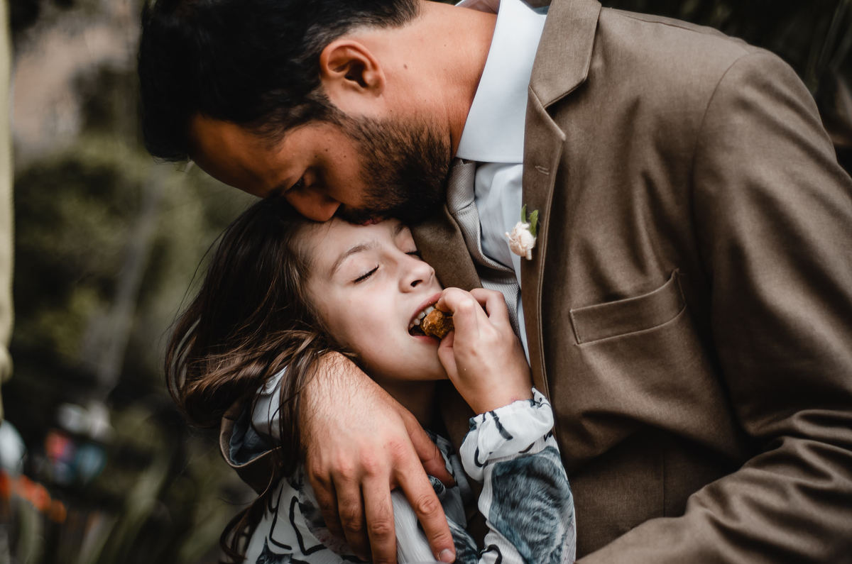 Fotografo de Casamento em Valença - RJ. Casamento em Rio Preto Minas Gerais. Foto da festa de casamento com o noivo dando um beijo na testa de uma criança