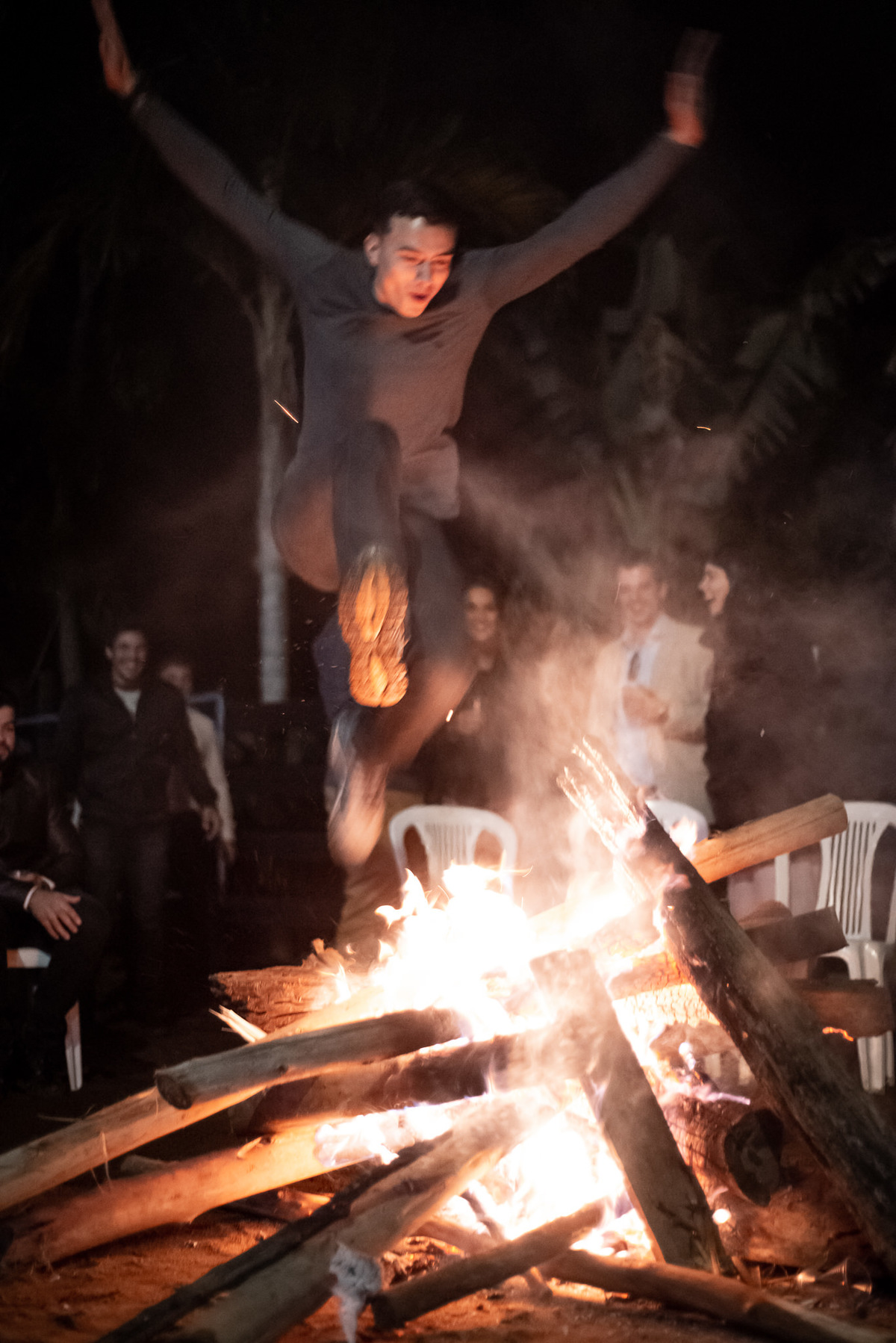 Fotografo de Casamento em Valença - RJ. Casamento em Rio Preto Minas Gerais. Foto da festa de casamento com o irmão da noiva pulando a fogueira