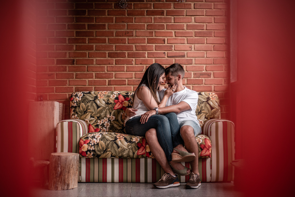 Ensaio externo de casal em Nova Friburgo, foto do casal sentado no sofá se fazendo carinho