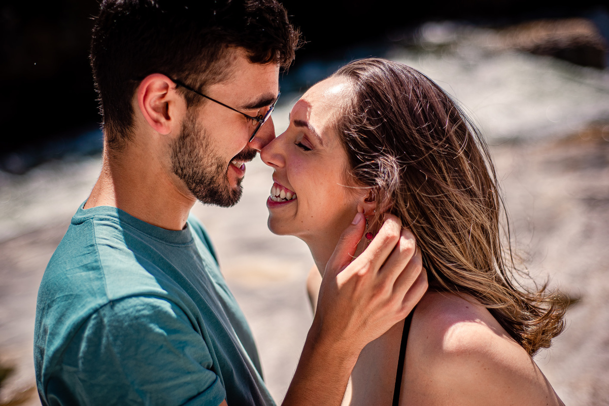 Ensaio externo de gestante na cachoeira em Nova Friburgo, foto do casal sorrindo um de frente para o outro