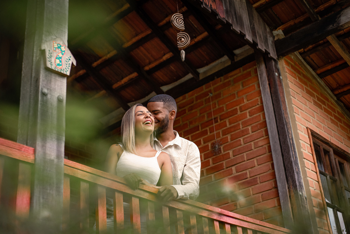 Ensaio externo pre-wedding em Nova Friburgo, foto da noiva e do noivo em uma varanda se fazendo carinho