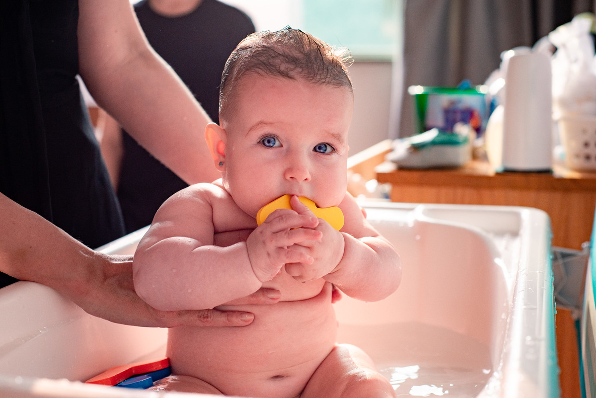 Ensaio de gestante e família em Nova Friburgo. Foto do bebê na banheiro com um parinho de borracha