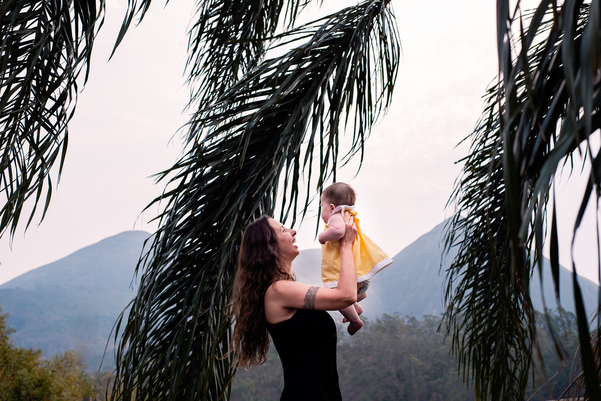 Ensaio de gestante e família em Nova Friburgo. Foto da mãe brincando com a filha no quintal