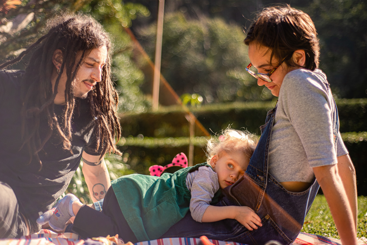 Fotógrafo de família em Nova Friburgo. Ensaio documental de família. Foto da filha deitada no colo da mãe na grama