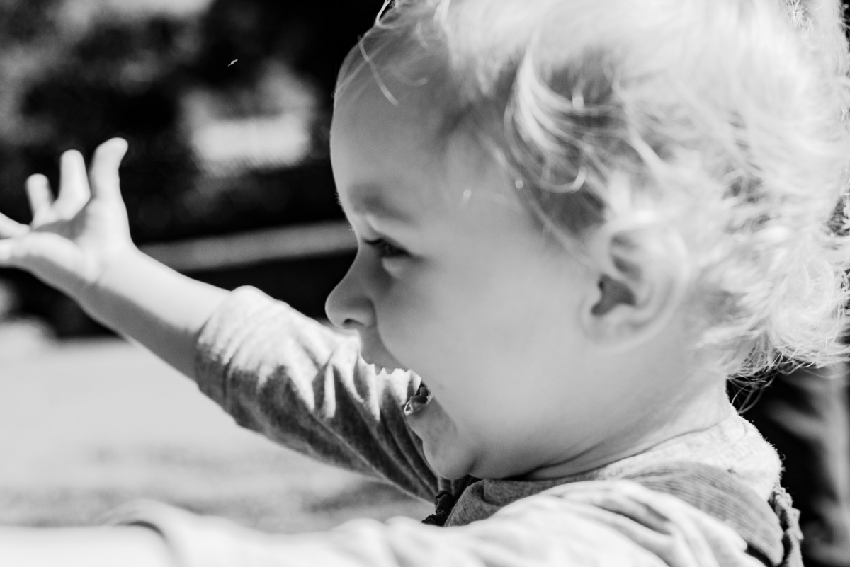 Fotógrafo de família em Nova Friburgo. Ensaio documental de família. Foto em preto e branco de close da criança correndo