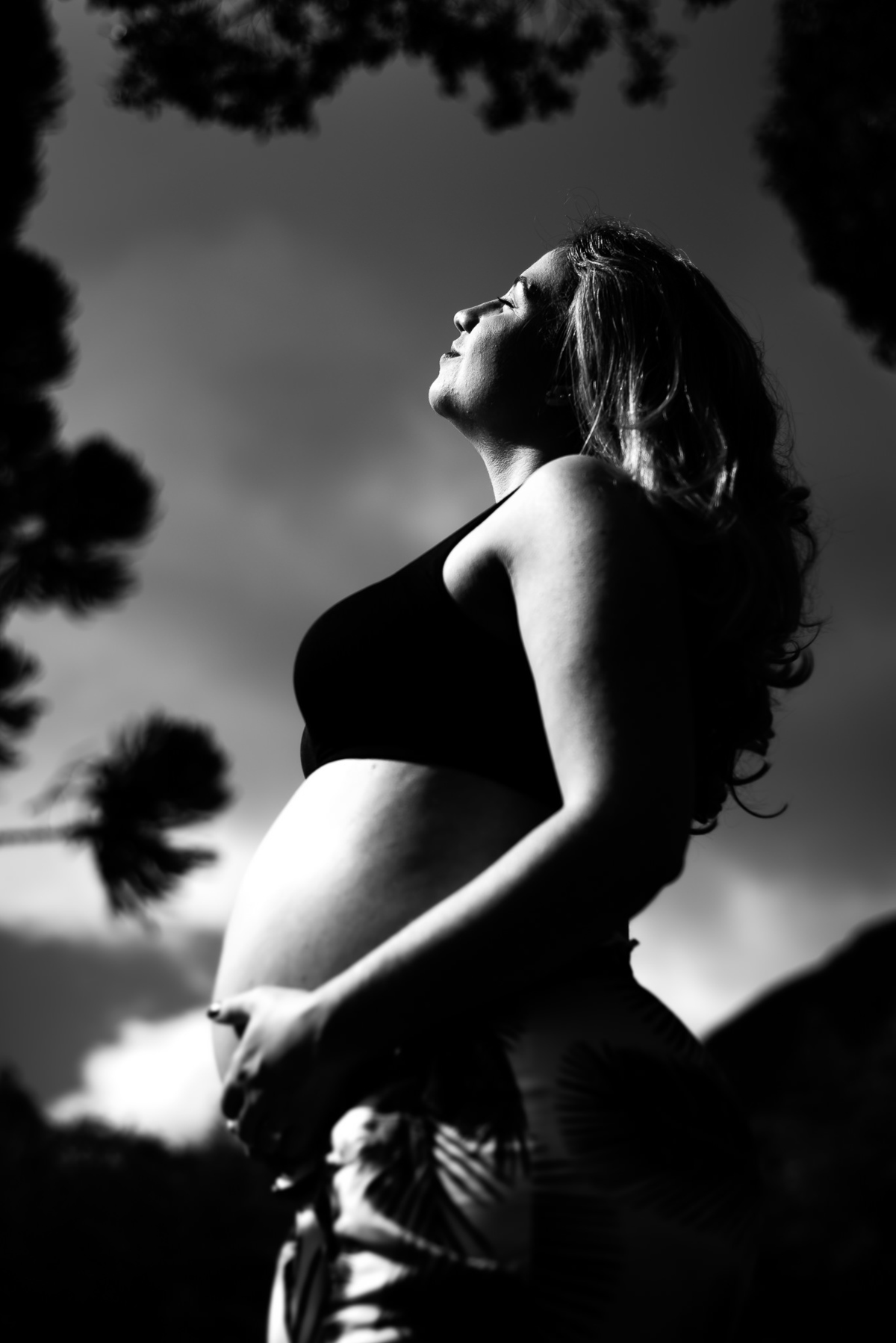 Fotógrafo em Nova Friburgo, ensaio Gestante. Foto conceitual em preto e branco da gestante com os olhos fechados e a mão na barriga