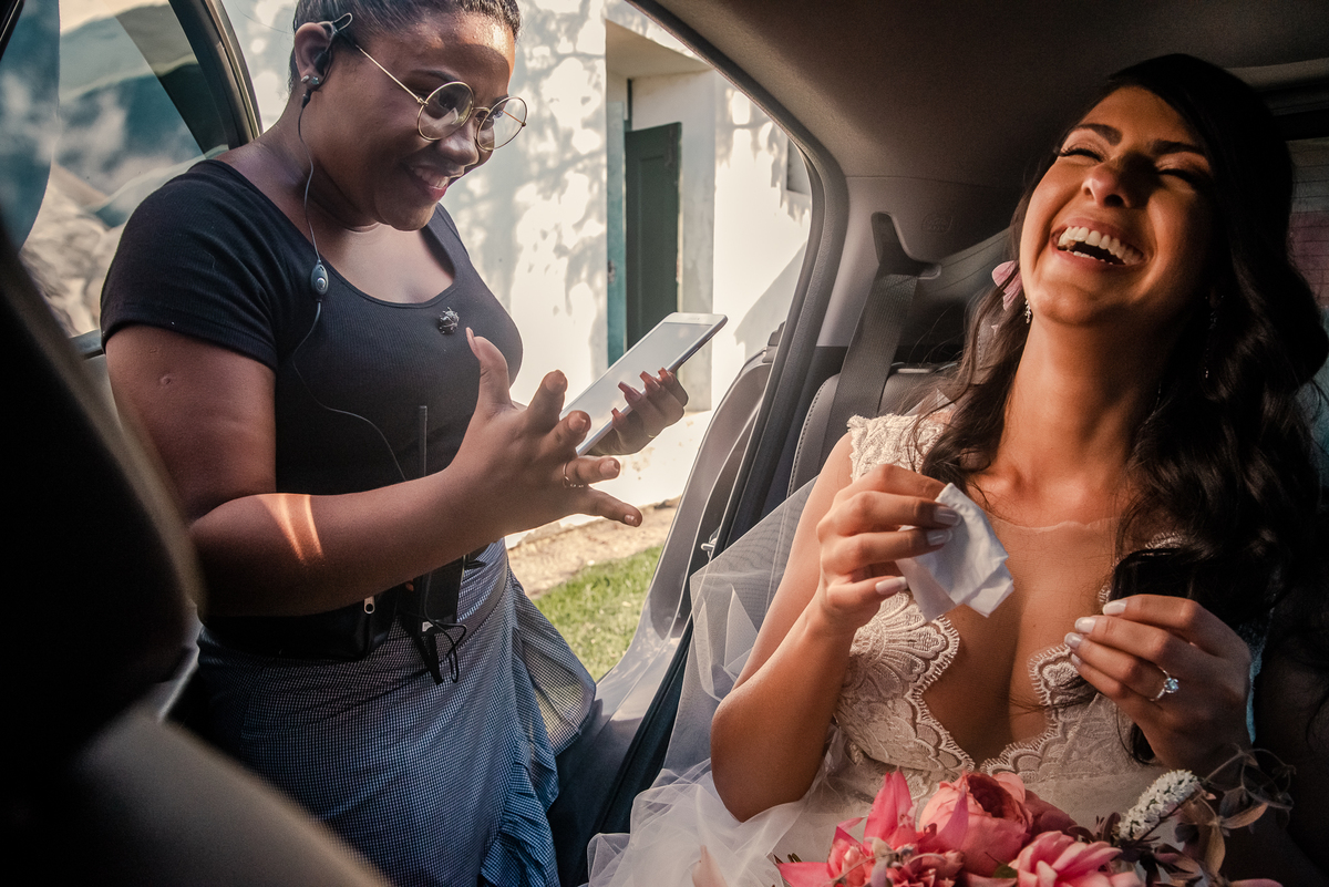 Fotografo de Casamento em Nova Friburgo - RJ. Destination Wedding em Paraty Mirim. Foto da assessora e noiva brincando antes da noiva entrar na igreja