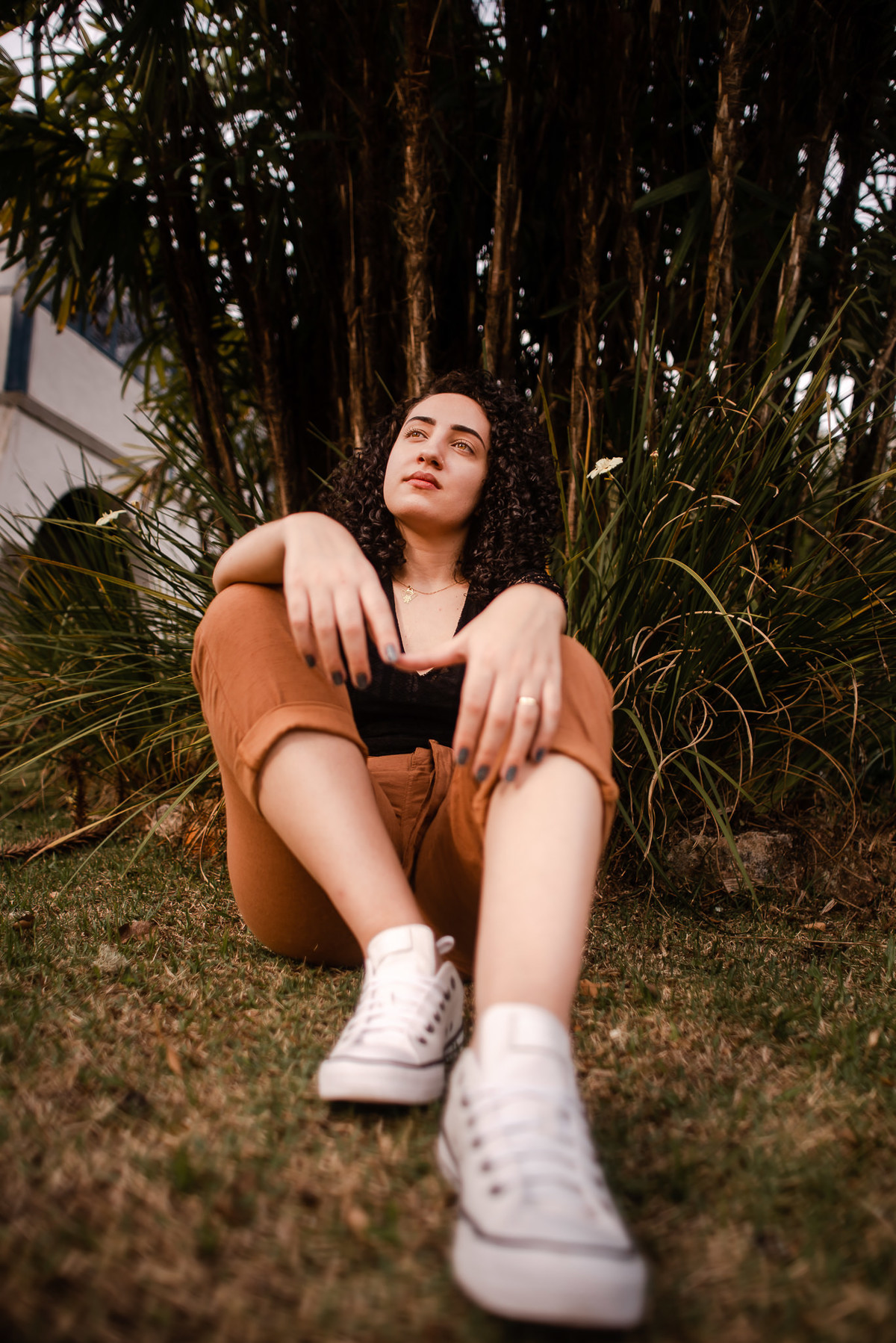 Fotógrafo em Nova Friburgo Ensaio Feminino, foto da mulher sentada na grama olhando para o horizonte