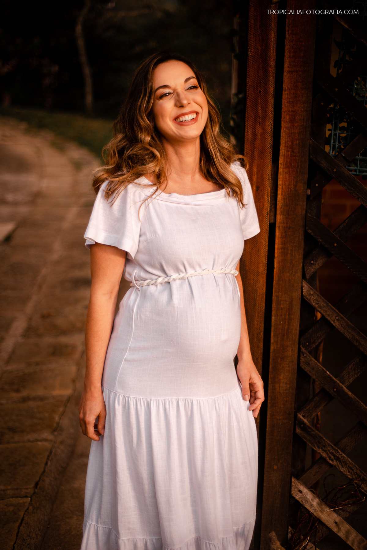 ensaio gestante em nova friburgo, região serrana do rio de janeiro no Hotel Oberland. Foto da gestante caminhando e iluminada pela luz do sol