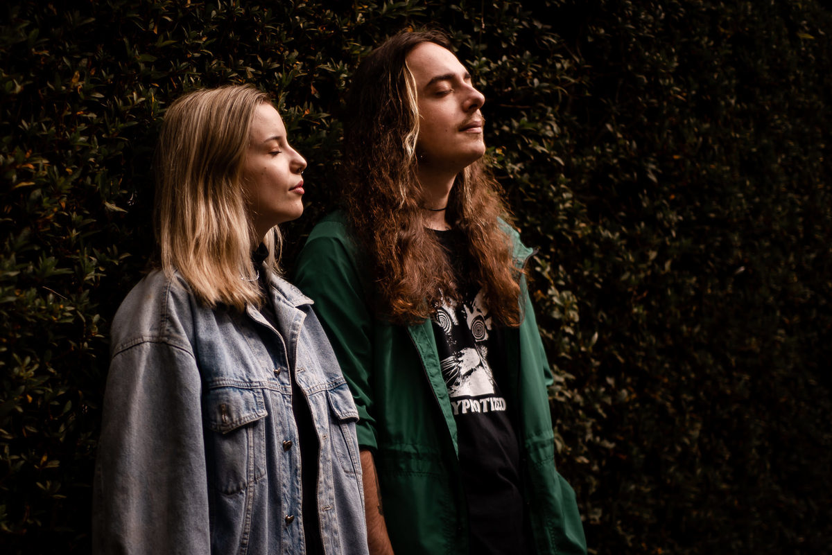 Fotógrafo de casamento em Nova Friburgo. Ensaio pré wedding do casal. Foto conceitual do casal, de olhos fechados, encostado em um muro de plantas