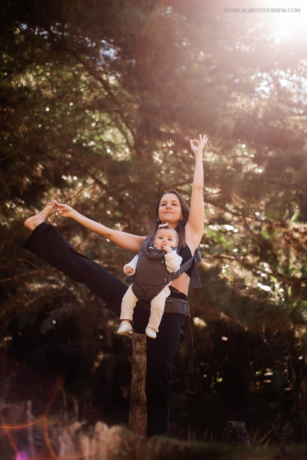 Ensaio documental de família em casa feito por fotógrafos em nova friburgo região serrana do rio de janeiro. Foto da mãe fazendo yoga com a filha no colo